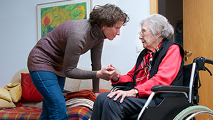Seniorin im Rollstuhl mit Pflegekraft